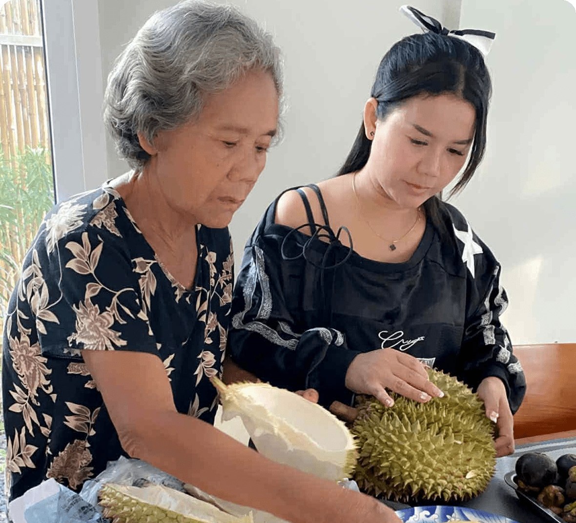 Women opening a durian fruit together