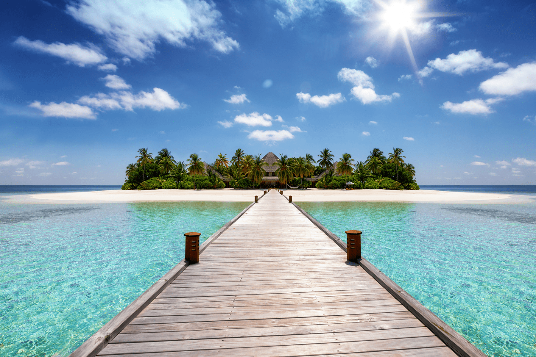 Wooden pier to tropical island over turquoise water