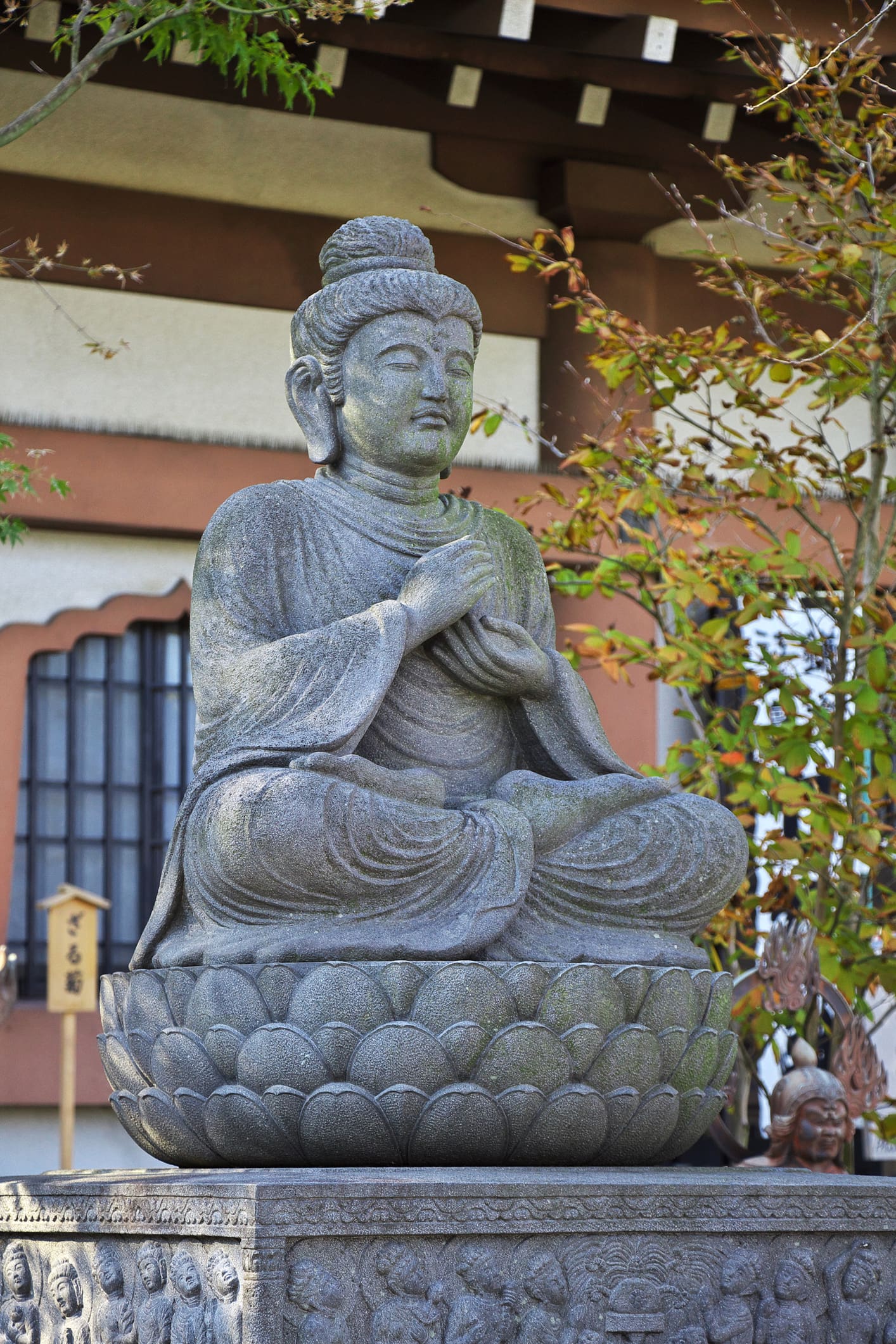 Seated stone Buddha statue on lotus pedestal