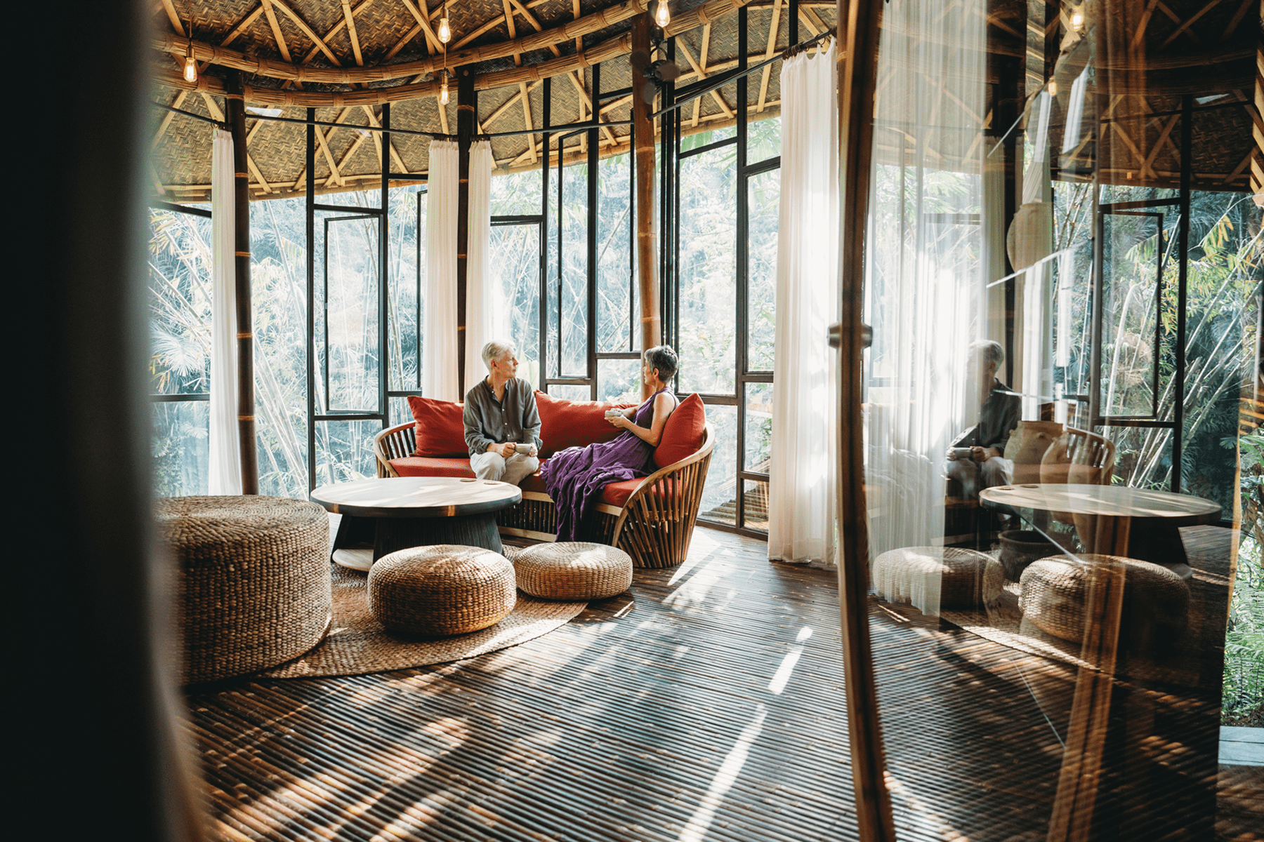 Two people conversing in tropical rattan lounge